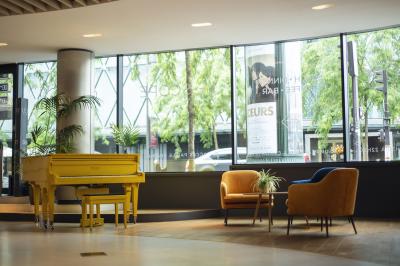 Salle de cinéma vide avec des rangées de sièges rouges et un éclairage tamisé sur les murs.