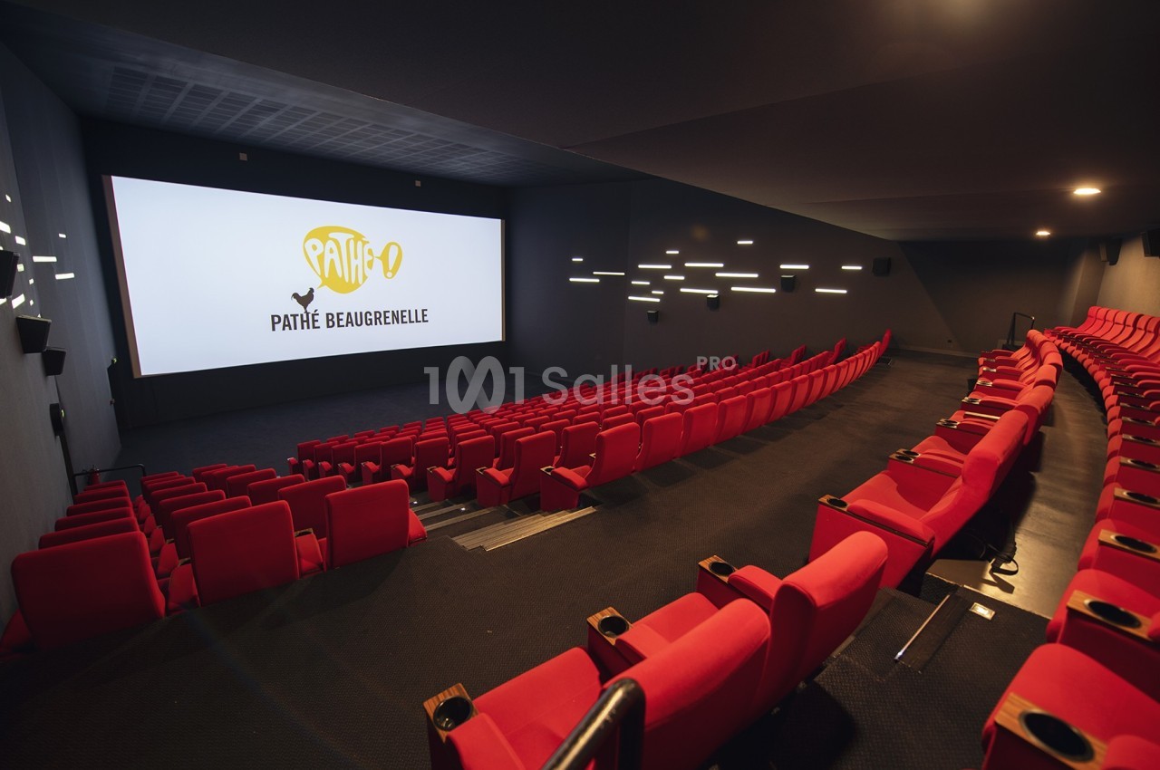 Salle de cinéma moderne avec sièges rouges, écran allumé affichant ’Pathé Beaugrenelle’ et éclairage mural discret.