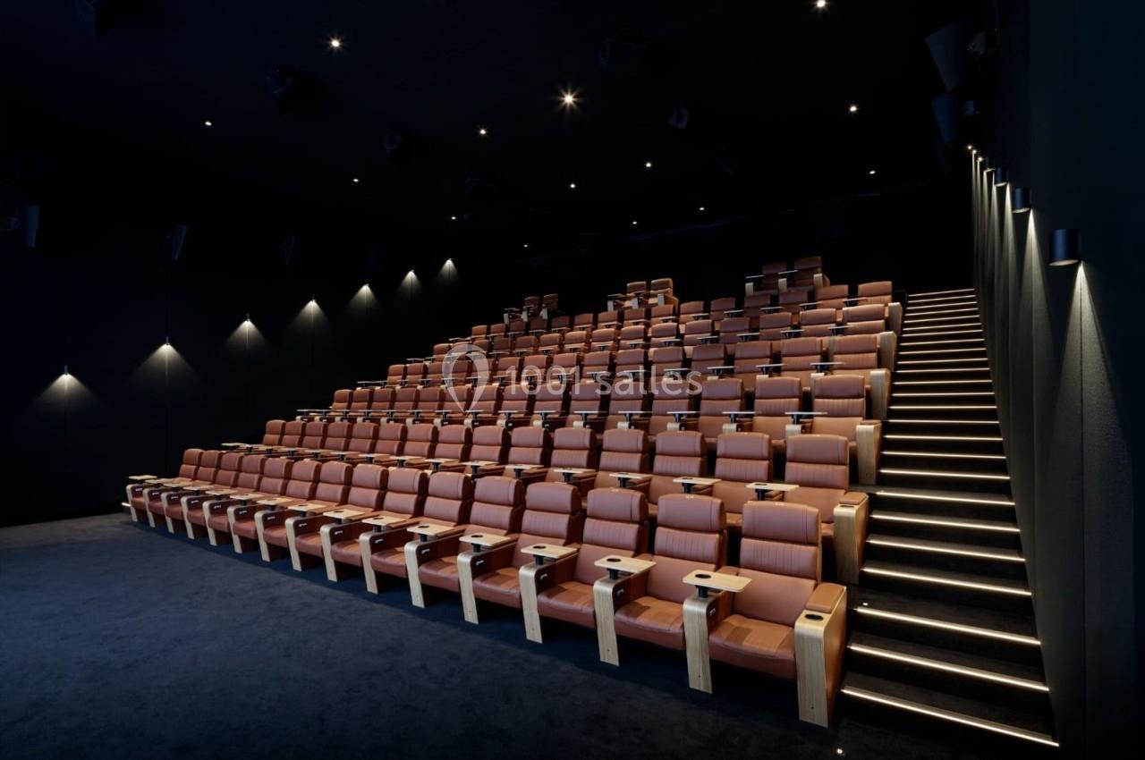Location salle Paris 9 (Paris) - Pathé Palace  #8 Salle de cinéma moderne avec sièges en cuir marron disposés en gradins et éclairage tamisé.