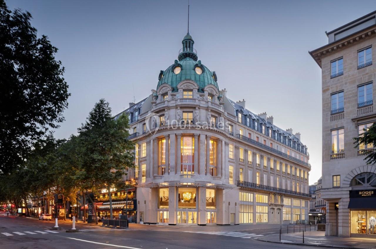 Location salle Paris 9 (Paris) - Pathé Palace  #1 Bâtiment haussmannien avec coupole verte, éclairé à la tombée de la nuit, situé à un carrefour parisien.