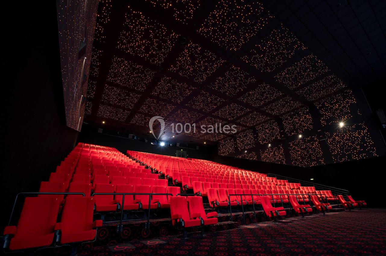 Location salle Paris 15 (Paris) - Pathé Aquaboulevard #2 Salle de cinéma vide avec des rangées de sièges rouges et un plafond illuminé par des lumières étoilées.