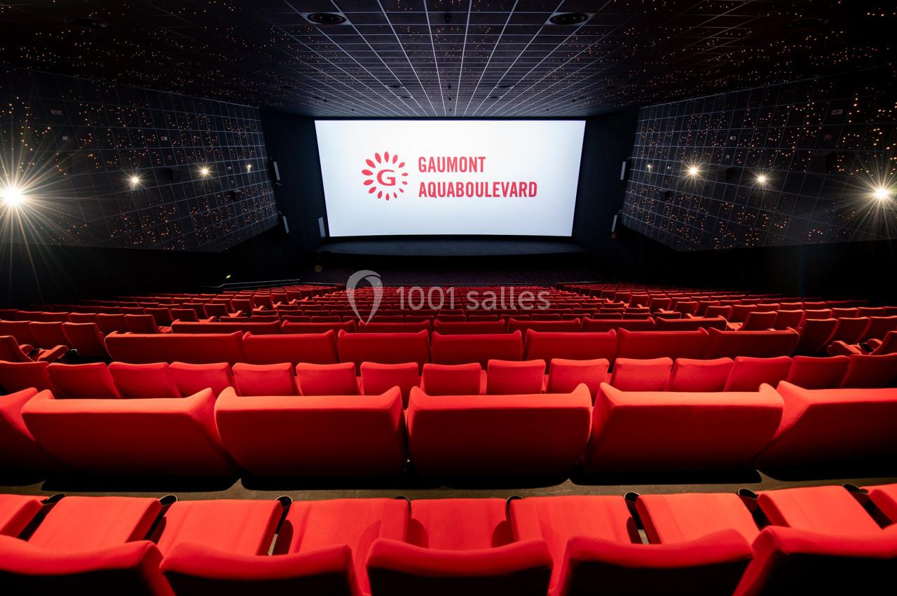 Location salle Paris 15 (Paris) - Pathé Aquaboulevard #3 Salle de cinéma vide avec rangées de sièges rouges et écran affichant ’Gaumont Aquaboulevard’.