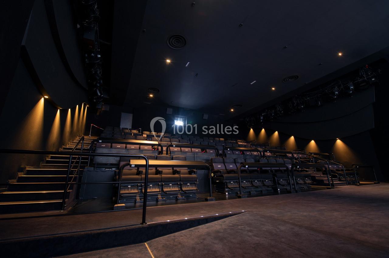 Location salle Paris 15 (Paris) - Pathé Aquaboulevard #15 Salle de théâtre vide avec rangées de sièges, éclairage tamisé et scène au premier plan.