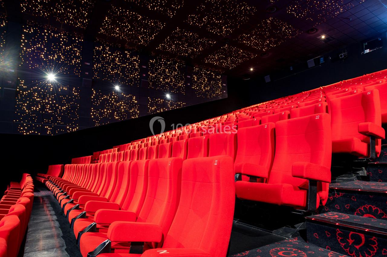 Location salle Paris 15 (Paris) - Pathé Aquaboulevard #17 Salle de cinéma vide avec des rangées de fauteuils rouges et un plafond décoré de lumières étoilées.