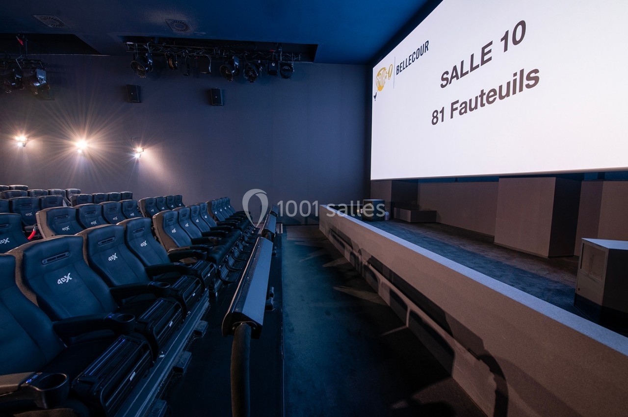 Salle de cinéma moderne avec 81 fauteuils inclinables, écran large et éclairage tamisé.