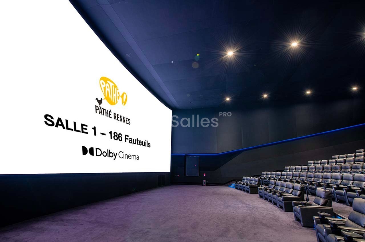 Salle de cinéma moderne avec écran géant, fauteuils inclinables et éclairage tamisé, affichant des informations sur l'écran.