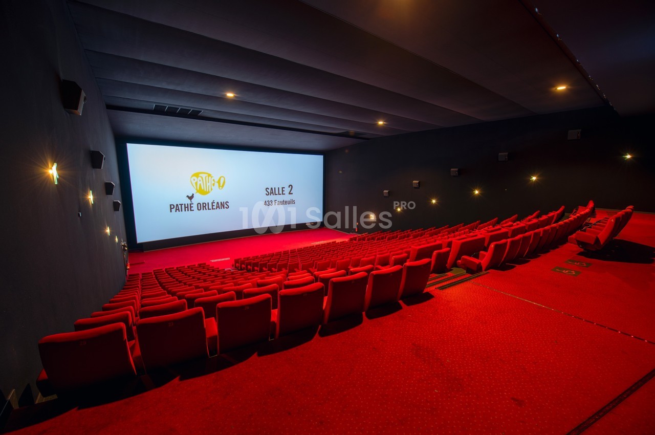 Salle de cinéma vide avec rangées de sièges rouges, écran allumé affichant ’Pathé Orléans, Salle 2, 432 fauteuils’.