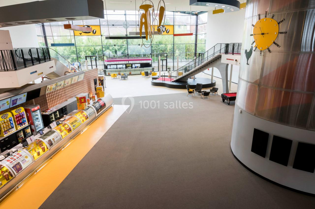 Location salle Liévin (Pas-de-Calais) - Pathé Liévin #6 Vue intérieure d'un espace lumineux avec des présentoirs de produits, une aire de jeux et de grandes baies vitrées.