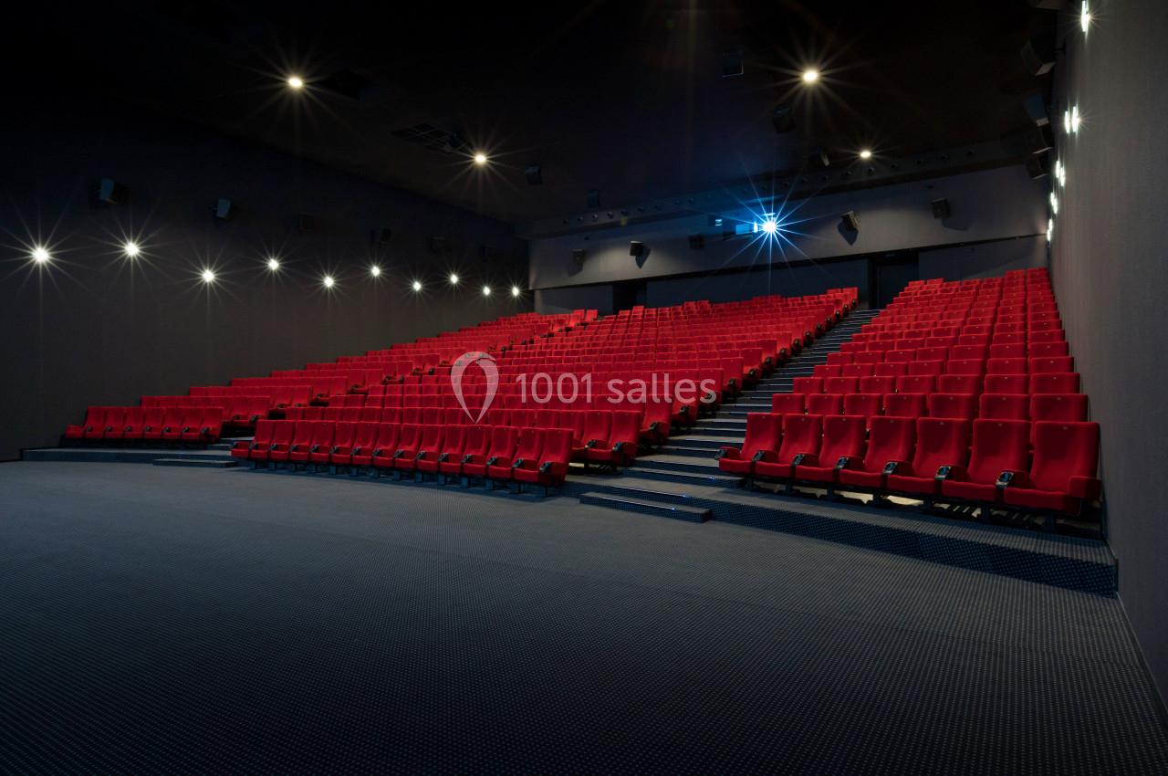 Location salle Liévin (Pas-de-Calais) - Pathé Liévin #2 Salle de cinéma vide avec des rangées de sièges rouges et un projecteur allumé.