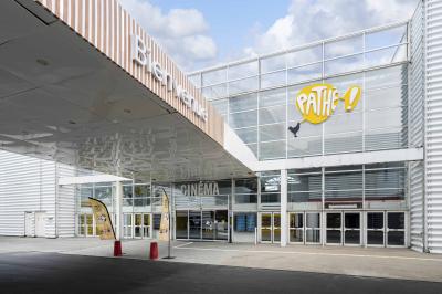 Miniature Location salle Coquelles (Pas-de-Calais) - Pathé Cité Europe #3 Couloir lumineux avec moquette grise, fauteuils, murs sombres, panneaux jaunes et ascenseurs numérotés 10.
