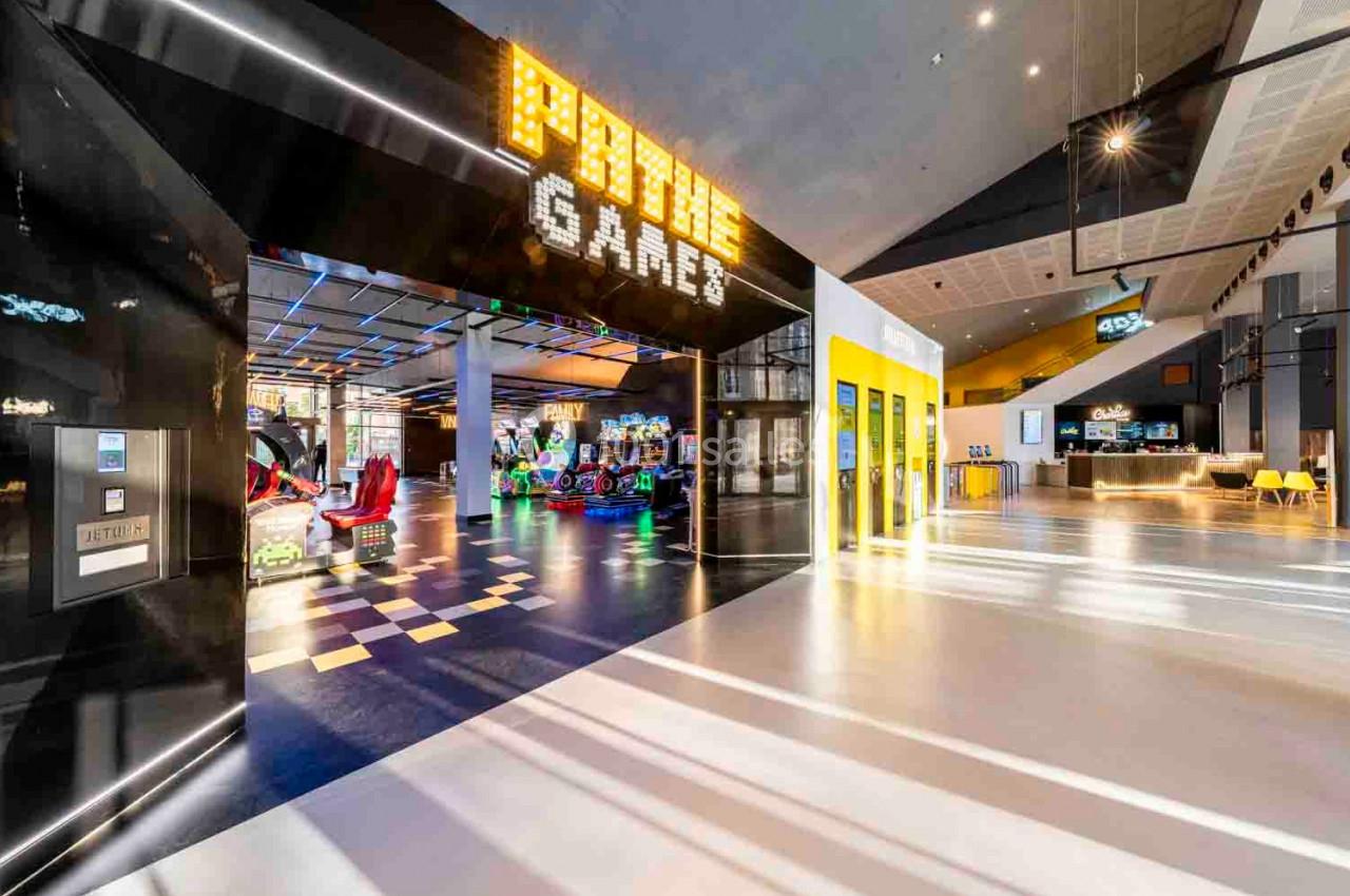 Entrée lumineuse d'une salle d'arcade moderne avec des jeux colorés visibles à l'intérieur.