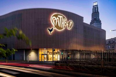 Miniature Location salle Amiens (Somme) - Pathé Amiens #14 Façade d'un cinéma Pathé illuminée au crépuscule, avec des bâtiments en arrière-plan et des traînées lumineuses de voitures.