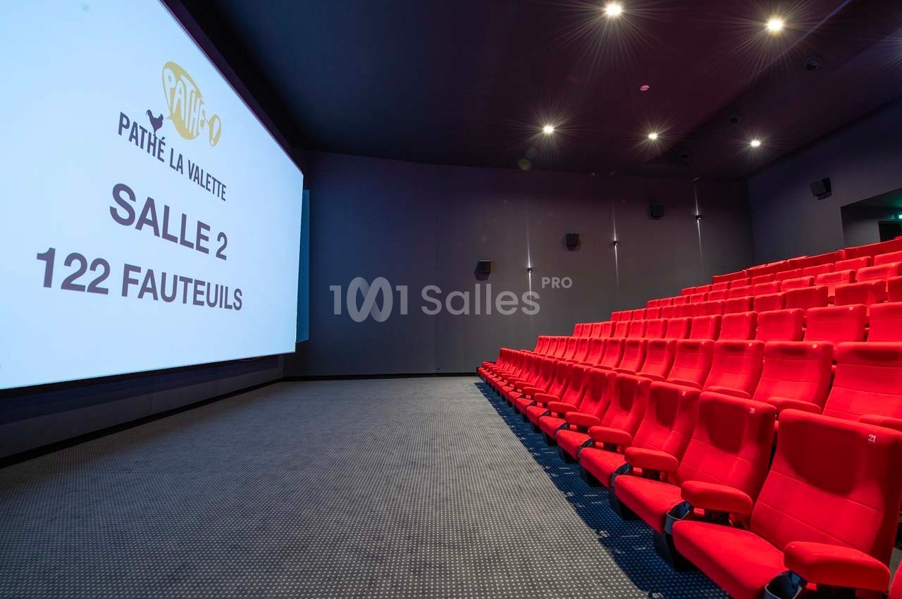 Salle de cinéma moderne avec des sièges rouges alignés et un écran affichant ’Pathé La Valette, Salle 2, 122 fauteuils’.