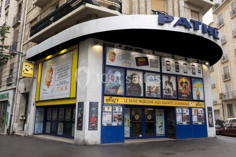 Façade d'un cinéma Pathé avec affiches de films exposées et entrée principale visible.