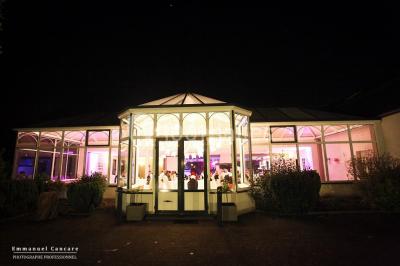 Miniature Location salle Leers (Nord) - Domaine du Blanc Maisnil #2 Jardin verdoyant avec pelouse, parterres fleuris, lampadaires verts et haies, entouré d'arbres sous un ciel dégagé.