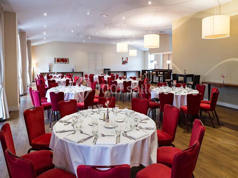 Location salle Aix-en-Provence (Bouches-du-Rhône) - Hôtel Aquabella & Spa #6 Salle de réception lumineuse avec tables rondes dressées, nappes blanches et chaises rouges.