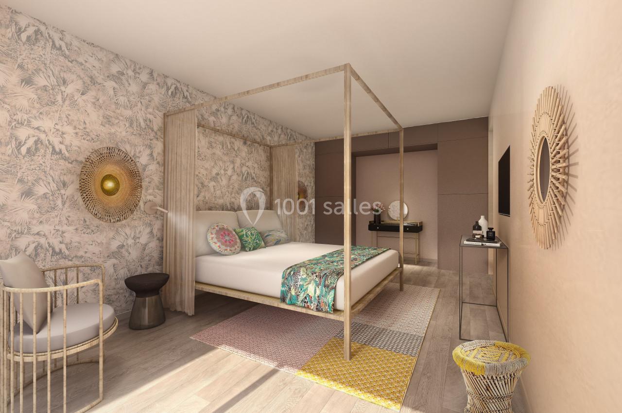 Location salle Aix-en-Provence (Bouches-du-Rhône) - Hôtel Aquabella & Spa #19 Chambre lumineuse avec lit à baldaquin, décorée de motifs tropicaux, meubles en bois clair et touches colorées.