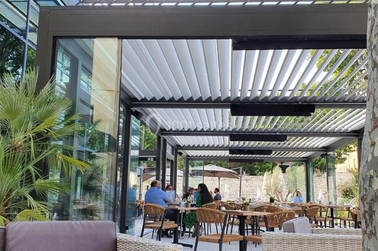 Location salle Aix-en-Provence (Bouches-du-Rhône) - Hôtel Aquabella & Spa #9 Terrasse extérieure moderne avec pergola à lames orientables, tables et chaises occupées par des clients.
