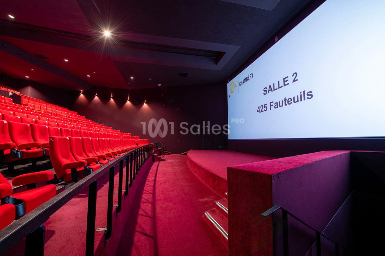 Salle de cinéma avec des sièges rouges alignés et un écran affichant ’Salle 2 - 425 fauteuils’.