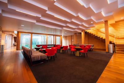 Miniature Location salle Paris 13 (Paris) - Pathé Les Fauvettes #2 Silhouette d'un coq noir sur une rambarde en bois devant un mur blanc avec le logo jaune ’Pathé !’ éclairé par la lumière.