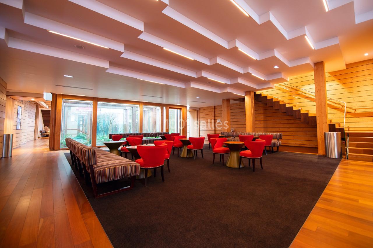 Location salle Paris 13 (Paris) - Pathé Les Fauvettes #2 Salle lumineuse avec des fauteuils rouges, des banquettes rayées, un escalier en bois et de grandes baies vitrées.
