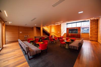 Miniature Location salle Paris 13 (Paris) - Pathé Les Fauvettes #4 Silhouette d'un coq noir sur une rambarde en bois devant un mur blanc avec le logo jaune ’Pathé !’ éclairé par la lumière.