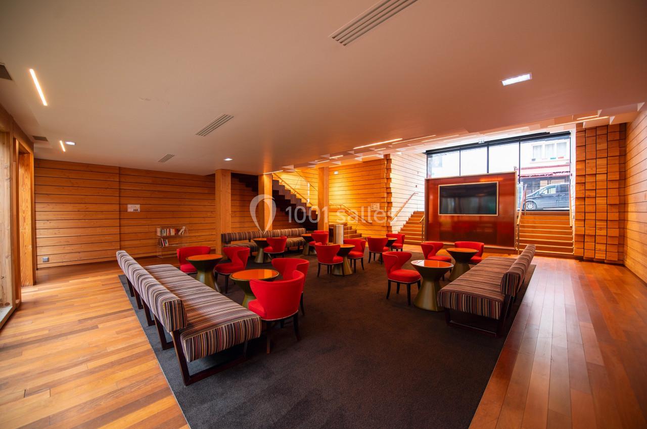Location salle Paris 13 (Paris) - Pathé Les Fauvettes #4 Salle avec mobilier moderne, comprenant des fauteuils rouges, des tables basses et des murs en bois clair.