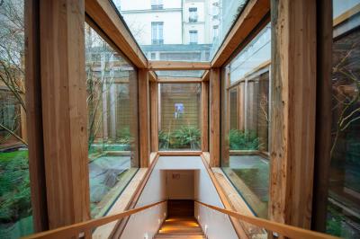 Miniature Location salle Paris 13 (Paris) - Pathé Les Fauvettes #8 Silhouette d'un coq noir sur une rambarde en bois devant un mur blanc avec le logo jaune ’Pathé !’ éclairé par la lumière.