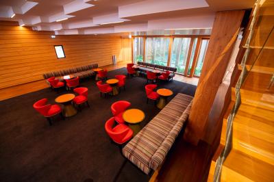 Miniature Location salle Paris 13 (Paris) - Pathé Les Fauvettes #7 Silhouette d'un coq noir sur une rambarde en bois devant un mur blanc avec le logo jaune ’Pathé !’ éclairé par la lumière.