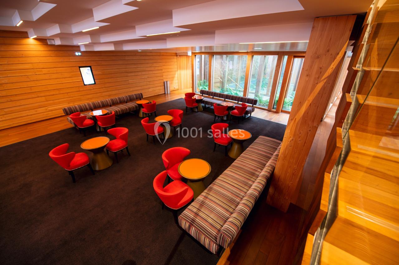 Location salle Paris 13 (Paris) - Pathé Les Fauvettes #7 Salle lumineuse avec tables rondes, chaises rouges et banquettes rayées, parquet en bois et grandes baies vitrées.