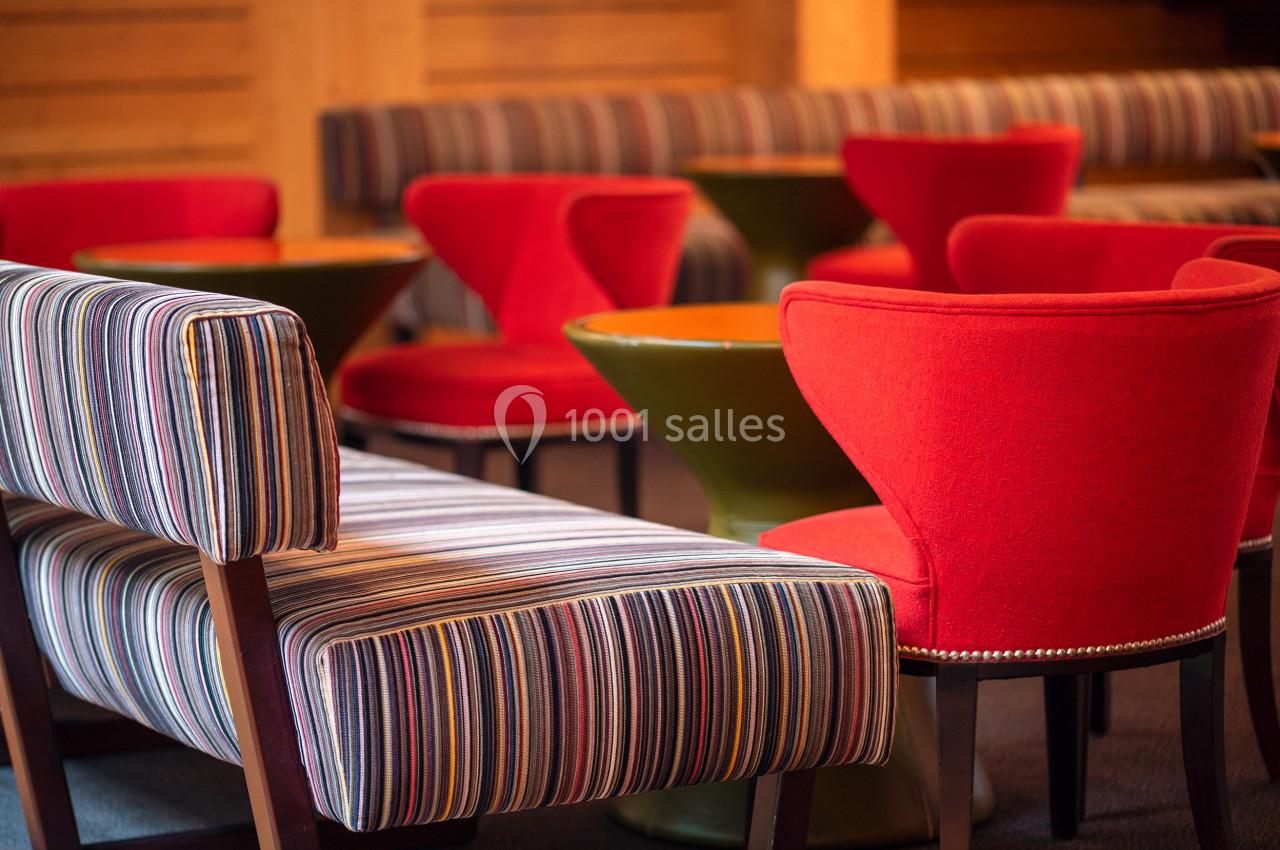 Location salle Paris 13 (Paris) - Pathé Les Fauvettes #10 Chaises rouges et banquettes rayées entourant des tables rondes dans un espace intérieur chaleureux.