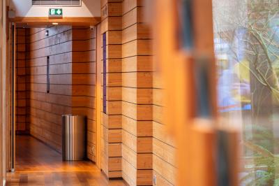 Miniature Location salle Paris 13 (Paris) - Pathé Les Fauvettes #11 Silhouette d'un coq noir sur une rambarde en bois devant un mur blanc avec le logo jaune ’Pathé !’ éclairé par la lumière.