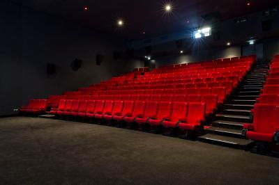 Miniature Location salle Paris 13 (Paris) - Pathé Les Fauvettes #3 Silhouette d'un coq noir sur une rambarde en bois devant un mur blanc avec le logo jaune ’Pathé !’ éclairé par la lumière.