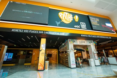 Miniature Location salle Tremblay-en-France (Seine-Saint-Denis) - Pathé Aéroville #16 Façade d'un cinéma Pathé avec enseignes lumineuses, affiches de films et entrée principale visible.