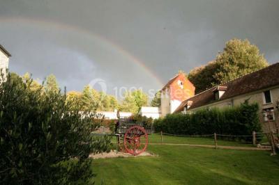 Miniature Location salle Messy (Seine-et-Marne) - Moulin de Moulignon #2 Cibles de tir à l'arc alignées sur un terrain herbeux, entourées d'arbres, avec deux personnes à proximité.