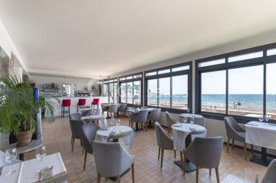 Miniature Location salle La Seyne-sur-Mer (Var) - Hôtel Restaurant George Sand #31 Chambre lumineuse avec lit double, décor beige et fenêtre ouverte offrant une vue sur la mer et les collines.