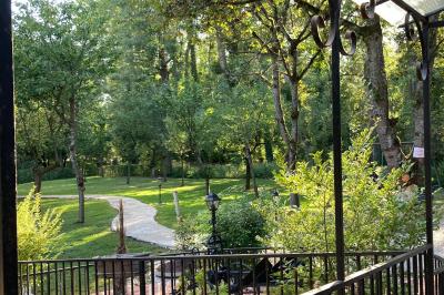 Tentes blanches installées sur une pelouse entourée d'arbres, avec tables et bottes de foin disposées en extérieur.