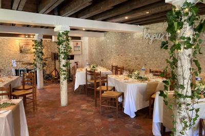 Tentes blanches installées sur une pelouse entourée d'arbres, avec tables et bottes de foin disposées en extérieur.