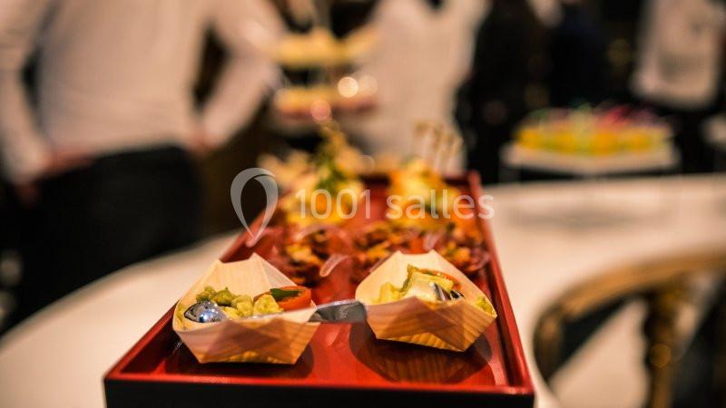 Plateau de dégustation avec des amuse-bouches variés présentés dans des contenants en bois sur une table.