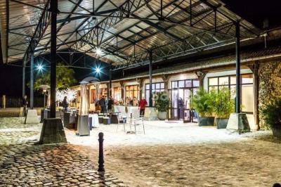 Miniature Location salle Lieusaint (Seine-et-Marne) - La Ferme de Villepecle #4 Groupe de personnes réunies en extérieur sous une structure métallique, devant un bâtiment en pierre et bois.