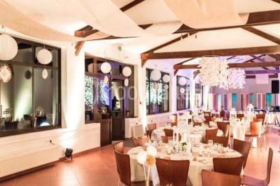 Salle de réunion avec une grande table rectangulaire, chaises noires, documents, bouteilles d'eau et écran de présentation.