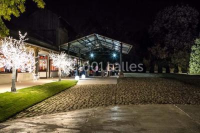 Salle de réunion avec une grande table rectangulaire, chaises noires, documents, bouteilles d'eau et écran de présentation.