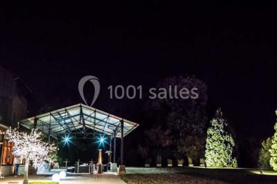 Salle de réunion avec une grande table rectangulaire, chaises noires, documents, bouteilles d'eau et écran de présentation.