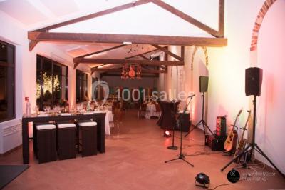 Salle de réunion avec une grande table rectangulaire, chaises noires, documents, bouteilles d'eau et écran de présentation.