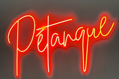 Salle de réunion avec une grande table rectangulaire, chaises noires, documents, bouteilles d'eau et écran de présentation.