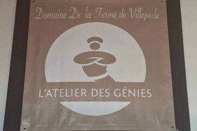 Salle de réunion avec une grande table rectangulaire, chaises noires, documents, bouteilles d'eau et écran de présentation.