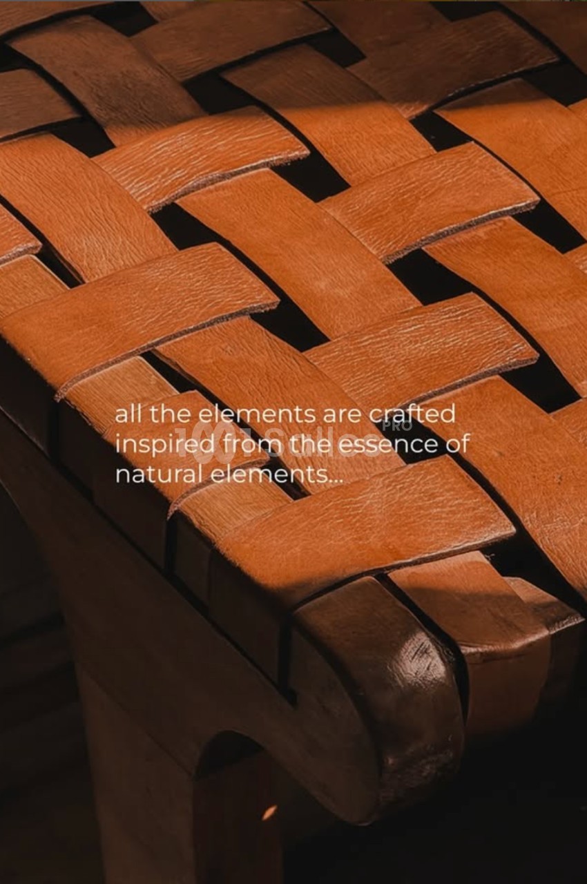Chaise en bois avec assise tressée en lanières de cuir, éclairée par une lumière chaude.