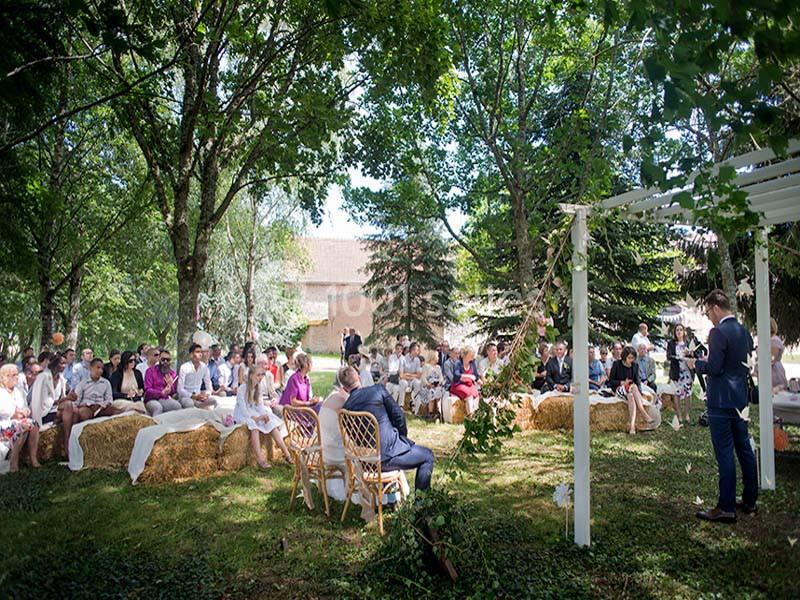 Location salle Maligny (Côte-d'Or) - Domaine du Grand Nanteux #20 Un groupe de personnes assises en plein air sous des arbres lors d'une cérémonie ou d'un événement.