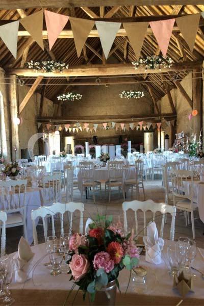 Location salle Maligny (Côte-d'Or) - Domaine du Grand Nanteux #19 Salle de réception décorée avec des guirlandes de fanions, des tables dressées et des compositions florales.