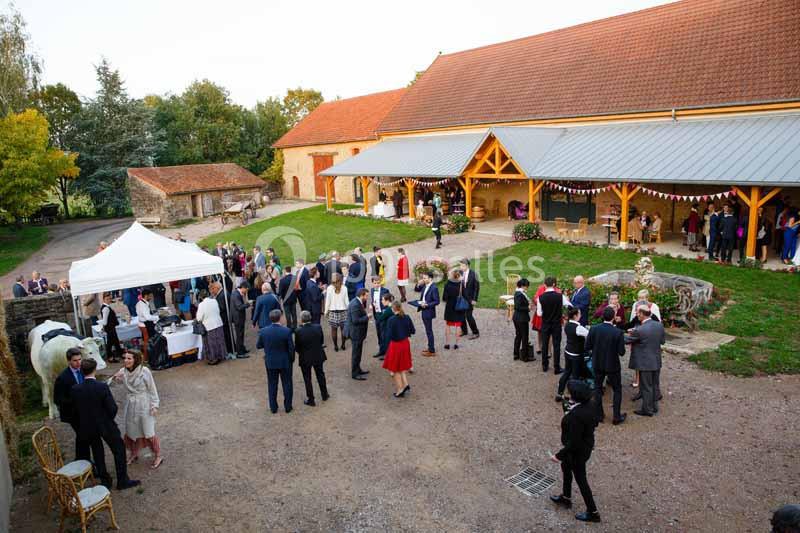 Location salle Maligny (Côte-d'Or) - Domaine du Grand Nanteux #9 Groupe de personnes rassemblées dans la cour d'une ferme pour un événement, avec des stands et des décorations festives.